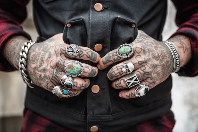Tattooed hands with rings